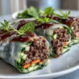 Colorful Thai Basil Beef Rolls sliced on a platter, ready to serve with a tangy, spicy dipping sauce.