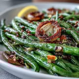 Tender green beans roasted to perfection with sliced garlic, finished with a sprinkle of lemon zest and toasted almonds.  