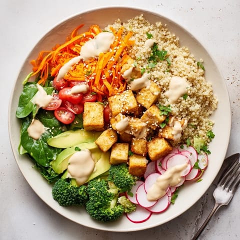 Sliced avocado, shredded carrots, and fresh cherry tomatoes add texture and color to a wholesome, restaurant-style Buddha Bowl, ready to enjoy.