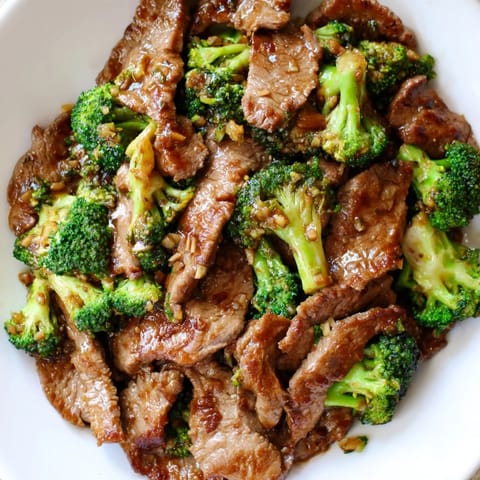 Sizzling Beef and Broccoli stir-fry with minced garlic and ginger in a wok.