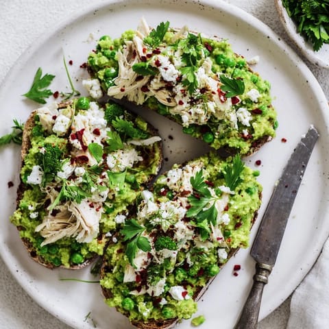 Bright open-faced Smashed Pea & Chicken Toast ready to serve, featuring creamy peas, tender chicken, and crumbled feta on crisp toasted bread.  