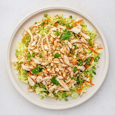 Colorful bowl of Crunchy Ramen Chicken Salad with toasted almonds and scallions, perfect for a quick lunch or potluck.