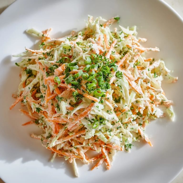 A refreshing Coleslaw with Apple served in a white bowl with a fork nearby, ready for a summer BBQ.