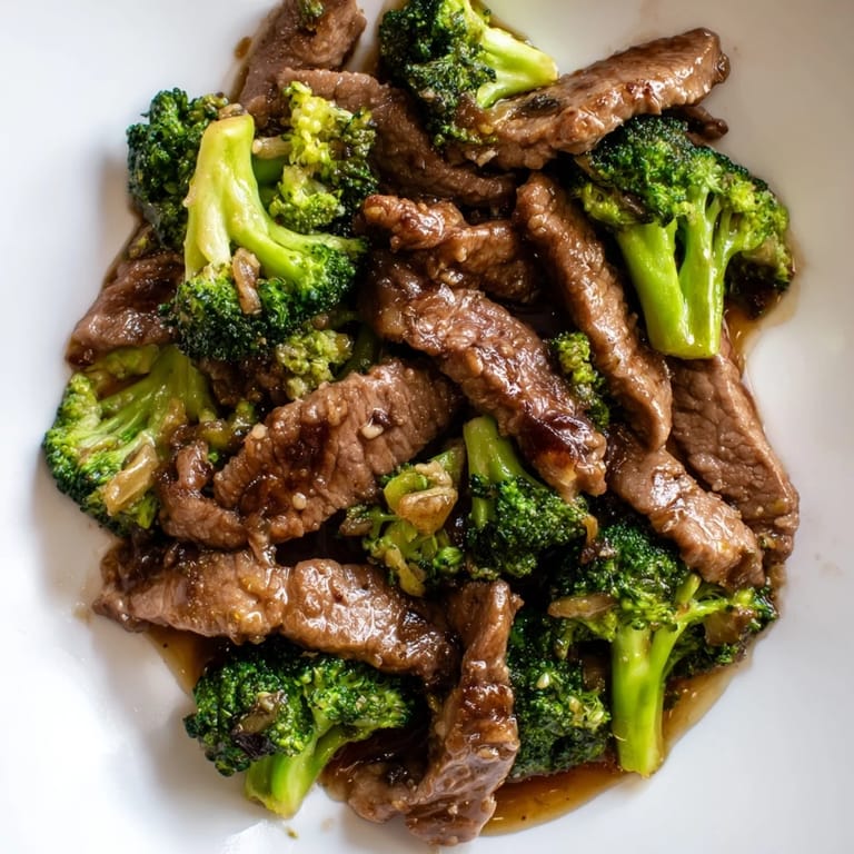 Savory Beef and Broccoli plated with sesame seeds and scallions, ready for dinner.