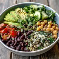 Hearty Three-Bean Power Bowl topped with sliced avocado and fresh cilantro, served as a vibrant, protein-packed vegetarian meal.
