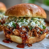 Hearty pulled BBQ chicken sandwiches with tangy sauce and crunchy coleslaw on soft brioche buns.